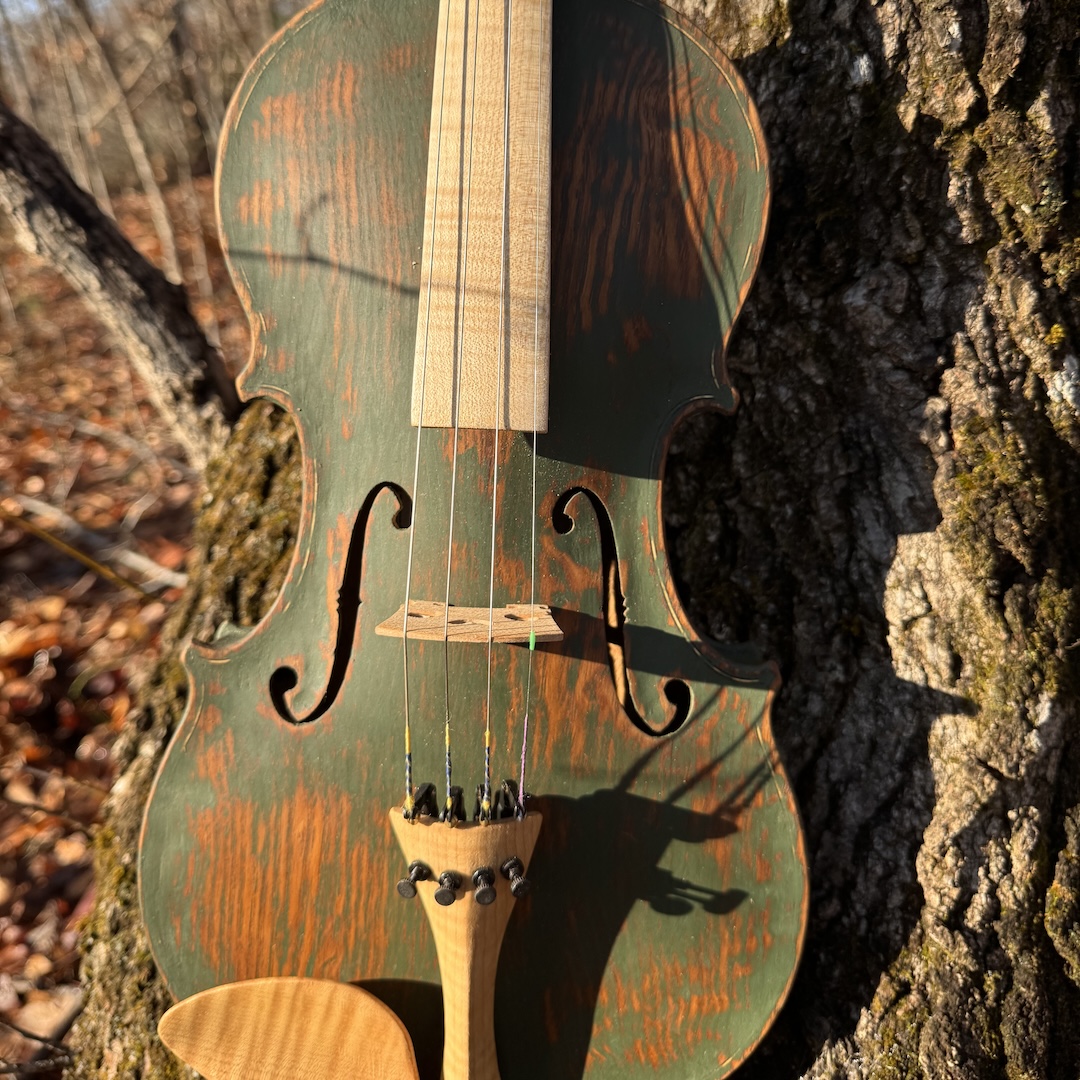 A closeup of one of John's cedar fiddles with a partially complete green finish.